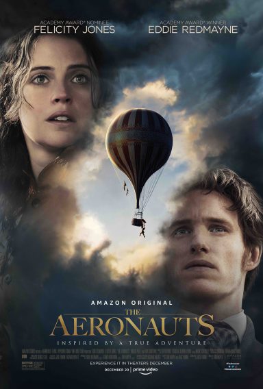 A woman and a man look upwards towards a hot air balloon against a cloudy sky.
